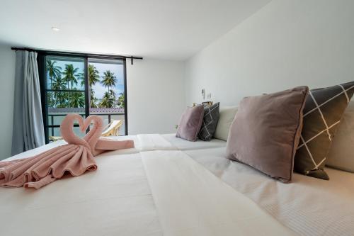 una camera da letto con un grande letto con un nastro rosa di Manao Pool Villa 9 - 5 Mins Walk To The Beach a Ko Lanta