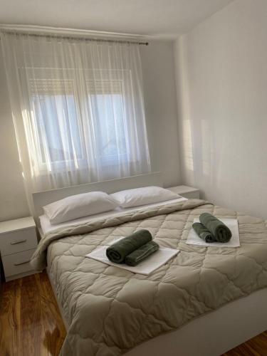 默主歌耶的住宿－Magnificat Apartment Medjugorje，一张白色的床,上面有两条绿色毛巾