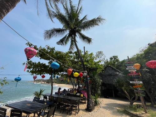 a beach with tables and chairs and a palm tree at Bãi Xếp Beach in Quy Nhon