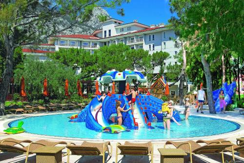 a group of people playing on a water slide in a pool at Akka Antedon Hotel - Premium Ultra All Inclusive in Beldibi