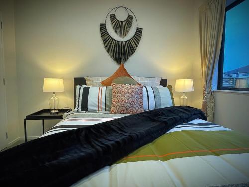 a bedroom with a large bed with two lamps at Flat Bush Holiday Accomodation in Auckland
