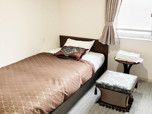 een slaapkamer met een bed, een raam en een tafel bij Guesthouse La Cava women's single room / Vacation STAY 21865 in Yokohama
