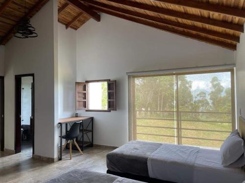 1 dormitorio con cama, escritorio y ventana en Villa Paulina en Guadalupe
