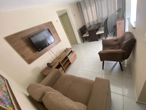 ein Wohnzimmer mit einem Sofa und einem Flachbild-TV in der Unterkunft Apartamento na Grande Natal (Condomínio Barcas) in Natal