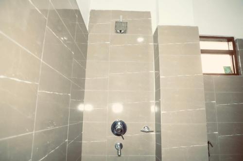 y baño con ducha y pared de piedra. en Hotel Nepal Inn Sauraha, en Sauraha