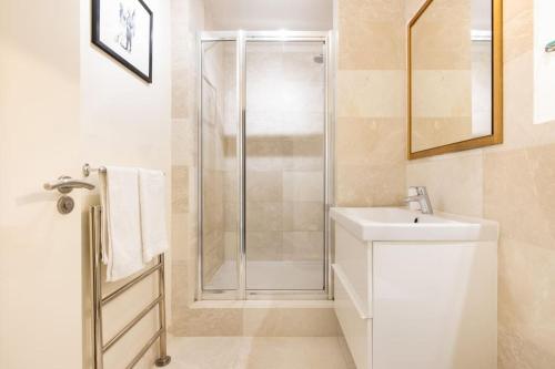 a white bathroom with a shower and a sink at Wild Roses Serviced Apartments - Tower Bridge in London