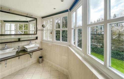 uma casa de banho com 2 lavatórios e janelas grandes em Lovely Home In Holten With Wifi em Holten