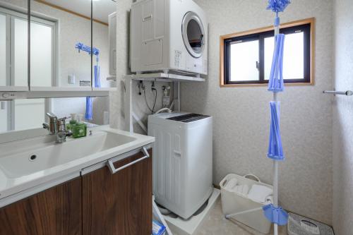 uma casa de banho com um lavatório e uma máquina de lavar roupa em Orange Line em Inbu