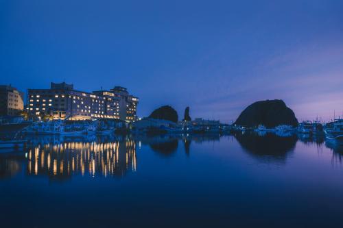 a view of a harbor at night with boats in the water at Kitakobushi Shiretoko Hotel & Resort in Shari