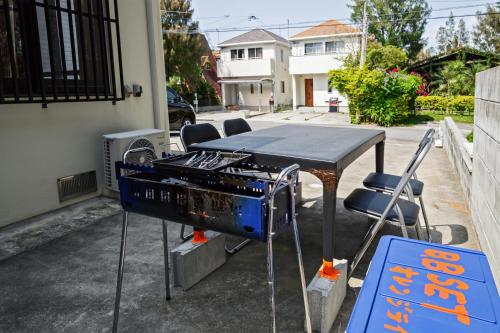 a grill with a table and chairs next to a street at Orange Line in Inbu