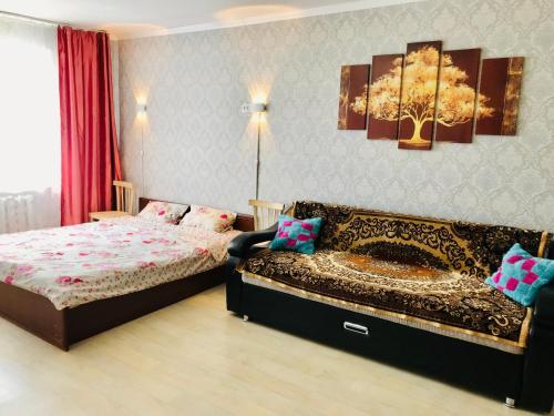 una camera con un letto e un divano di Flat in the city center a Karagandy