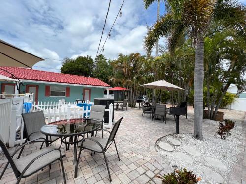 un patio con tavoli, sedie e una palma di Blue Waters Treasure Island a Treasure Island