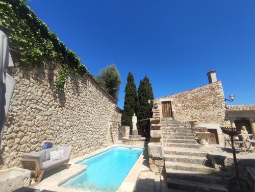 una piscina junto a una pared de piedra y escaleras en Casa histórica ciclismo, piscina, sauna y jacuzzi, en Lloseta