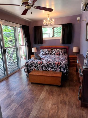 een slaapkamer met een bed en een plafondventilator bij Tropical Poolside Retreat in Nelly Bay