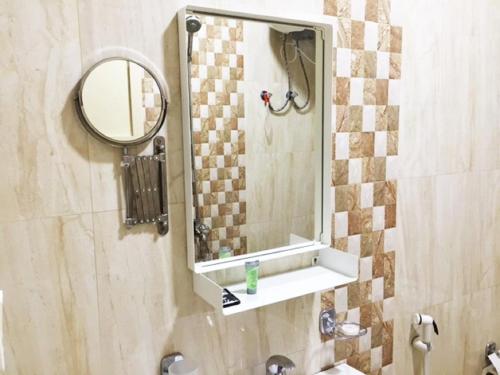 a bathroom with a mirror and a sink at Hona Al Holm Furnished Units in Dammam