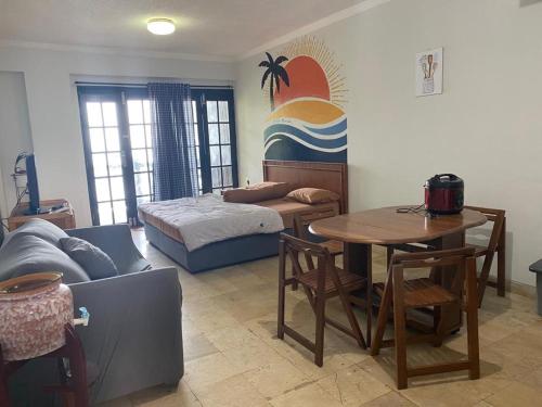 ein Wohnzimmer mit einem Sofa, einem Tisch und einem Bett in der Unterkunft ocean view studio room by hello beach in Sukarame