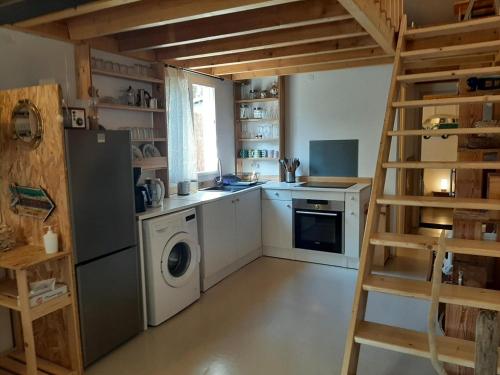 une cuisine avec lave-linge et sèche-linge et une échelle dans l'établissement Maison confortable pour 4 à Soorts-Hossegor avec terrasse et parking - FR-1-239-929, à Soorts-Hossegor