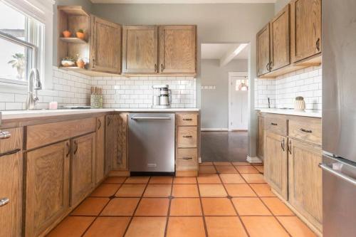 a kitchen with wooden cabinets and an orange tiled floor at Garfield Historic Chateau in Downtown Phoenix in Phoenix