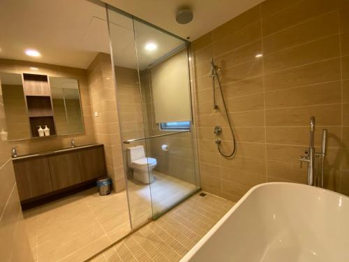 a bathroom with a tub and a toilet and a shower at BY THE SEA - Penthouse 3 bedroom in Batu Ferringhi