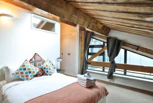 een slaapkamer met een bed en een groot raam bij Wild Roses Serviced Apartments - ExCel Warehouse 1 in Londen