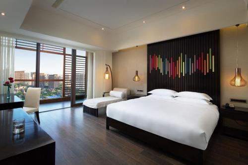 ein Schlafzimmer mit einem großen weißen Bett und einer farbenfrohen Wand in der Unterkunft Mangrove Tree Resort World Sanya Bay-Coconut in Sanya