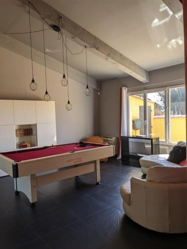 a living room with a pool table and a couch at Le Mas Del Cavalier in Baho