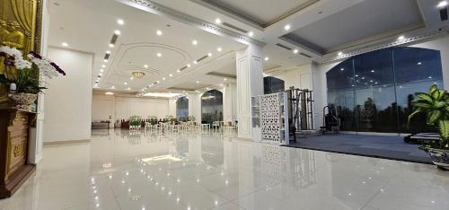 a large room with a lobby with tables and chairs at Grand Hill Hotel & Apartment in Hai Phong