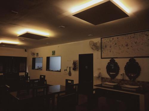 a dining room with tables and chairs and a projection screen at The Laughing Woods AC Resort in Kotagiri