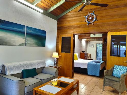 sala de estar con sofá y cama en Beachside Cottage - A Private Peaceful Hidden Gem 50m to Beach, en Nelly Bay