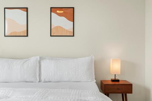 um quarto com uma cama branca com três fotografias na parede em Luxury Retreat - King Beds, Hot Tub, & Pool - Family & Remote Work Friendly em Reno