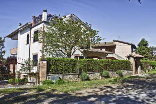 a white house with a fence and a tree at La Casa di Gigliola in Monticiano