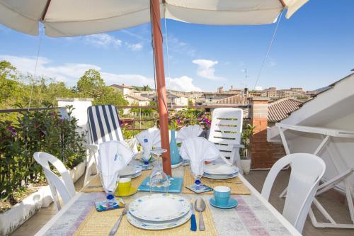 a table with chairs and an umbrella on a balcony at La Casa di Gigliola in Monticiano