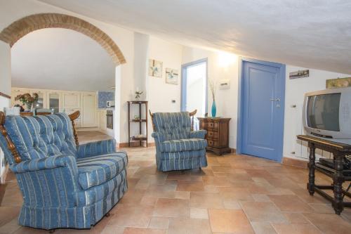 a living room with two chairs and a tv at La Casa di Gigliola in Monticiano