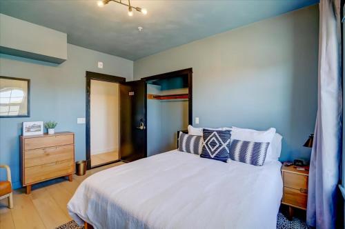 a bedroom with a bed with blue walls and a dresser at 202 - Single Queen in Waunakee