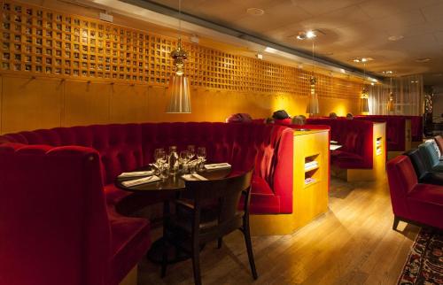 a restaurant with a red couch and a table at Hotel Rival in Stockholm