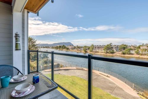 a balcony with a table and a view of the water at Rivers Edge at Bridgeport in Seaside