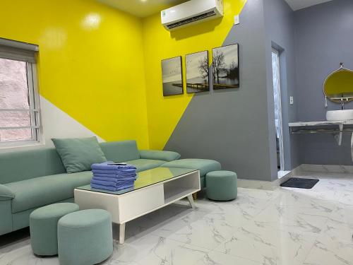 a living room with a couch and a yellow wall at Cat Ba Santorini Homestay in Cat Ba