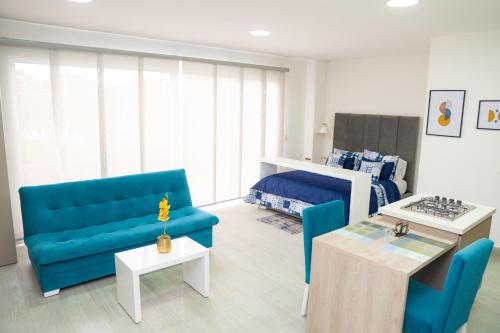 a living room with a blue couch and a bed at Aparta suite tequendama in Cali
