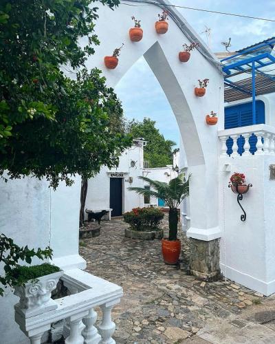 a white building with an arch and a white bench at El santorini colombiano cabaña in Puerto Triunfo