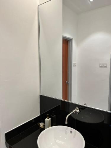 a bathroom with a sink and a large mirror at Inn Homestay in Teluk Intan