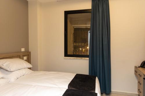 a bedroom with a bed and a window with a mirror at Saint Jacob Hotel in Nazareth
