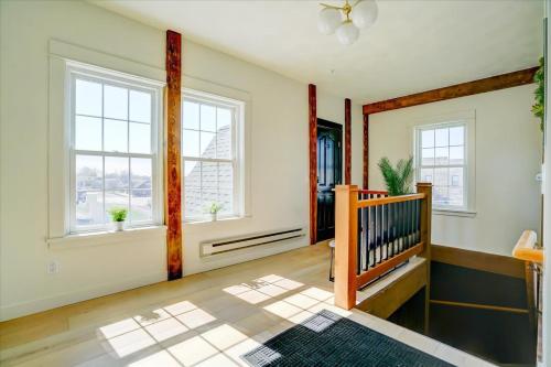 an empty living room with a staircase and windows at 205 - Queen Suite in Waunakee