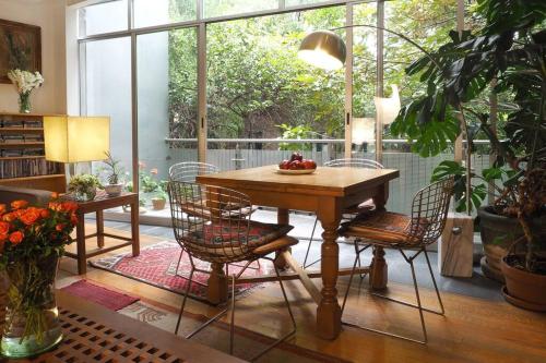 a table and chairs in a room with a large window at Casa Tabasco By The Local Way in Mexico City