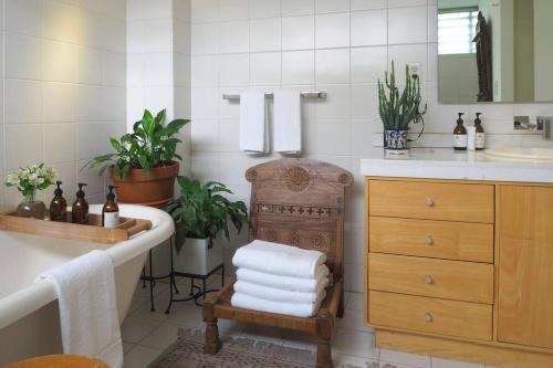 a bathroom with a tub and a sink and a chair at Casa Tabasco By The Local Way in Mexico City