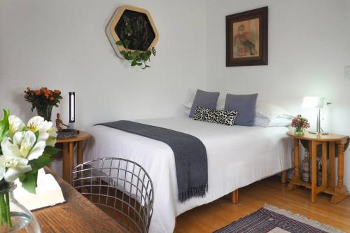 a bedroom with a bed and two tables and a mirror at Casa Tabasco By The Local Way in Mexico City