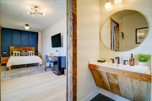 a bathroom with a sink and a mirror and a bed at 205 - Queen Suite in Waunakee