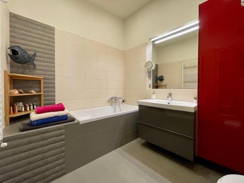 bagno con vasca, lavandino e specchio di Penthouse w Private Rooftop and Free parking a Budapest