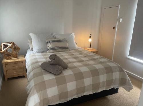 ein Schlafzimmer mit einem Bett mit zwei Handtüchern darauf in der Unterkunft CBD Apartment, River View in Hamilton