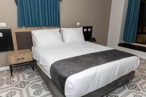 a bedroom with a large bed with white sheets and pillows at Saint Jacob Hotel in Nazareth
