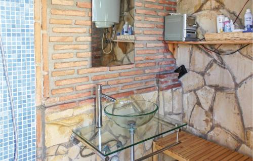 アルムニェーカルにあるStunning Home In Almuecar With 3 Bedrooms, Wifi And Outdoor Swimming Poolのレンガ造りの壁の部屋のガラステーブル